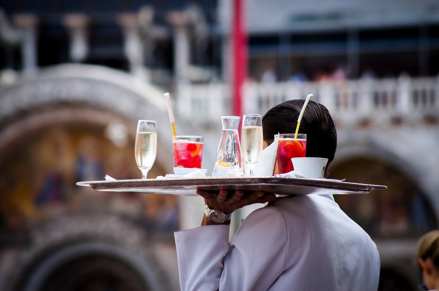 A picture of a man carrying drinks.